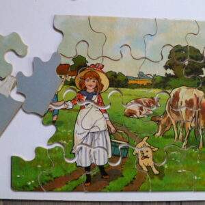 Oude puzzel, meisje en jongen in een wei met koeien