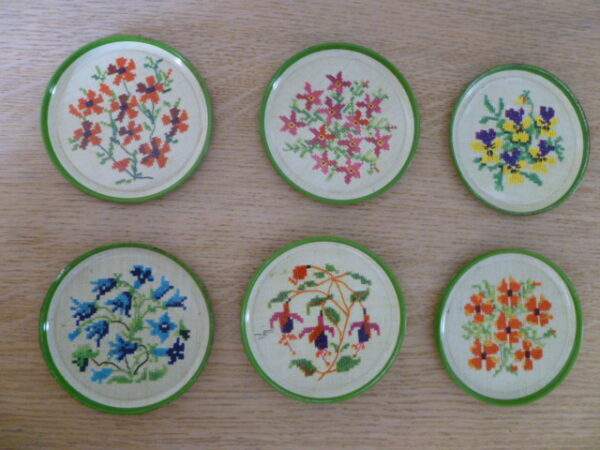 Vintage metalen onderzetters met geborduurd bloemmotief