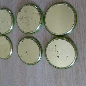 Vintage metalen onderzetters met geborduurd bloemmotief