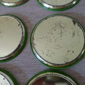 Vintage metalen onderzetters met geborduurd bloemmotief